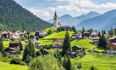 Graubuenden, Switzerland with view of houses on green grassy hills