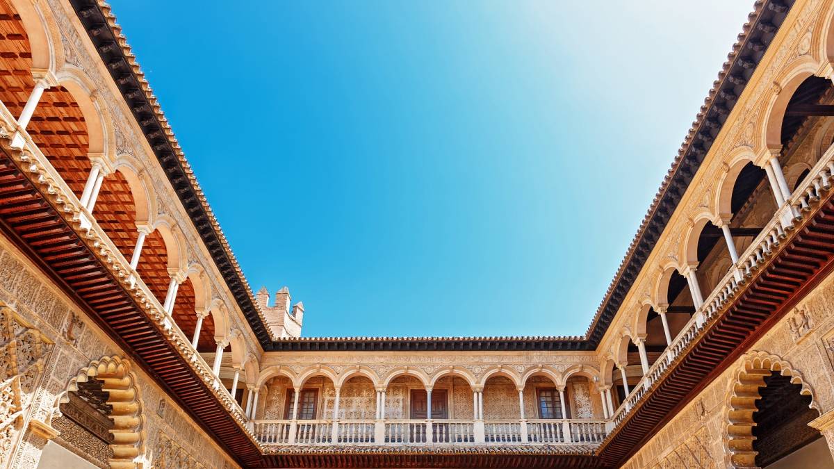 Things to do in Spain - Palace of Alcazar, Famous Andalusian Architecture. Old Arab Palace in Seville, Spain. Ornamented Arch and Column. Famous travel destination.